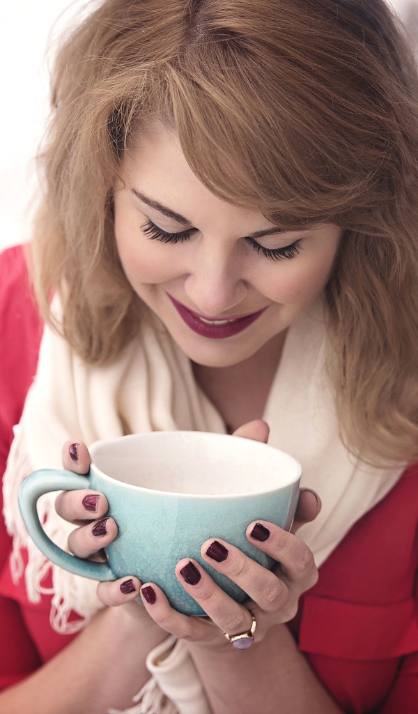 Милая девушка согревается горячим кофе