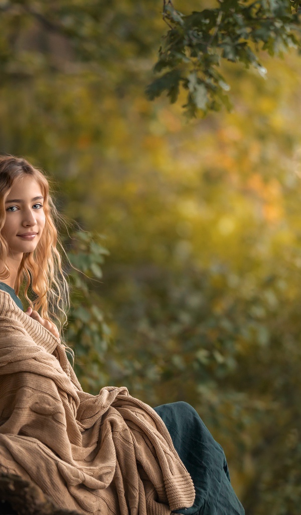 Милая длинноволосая девушка в теплой накидке 