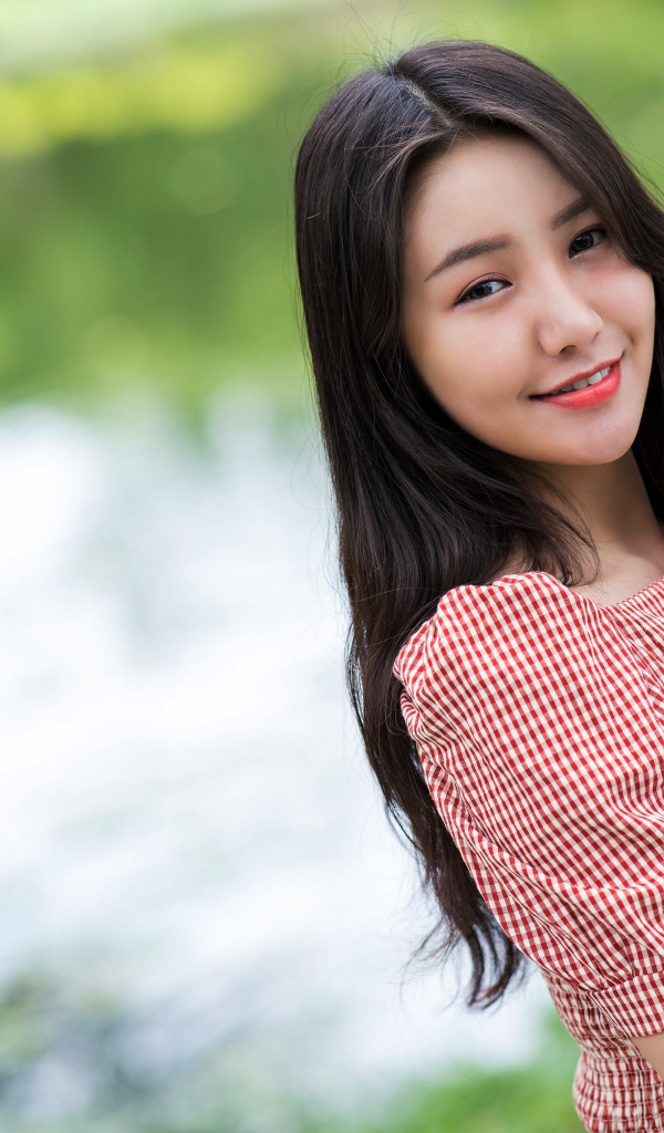 Милая улыбка молодой длинноволосой азиатки