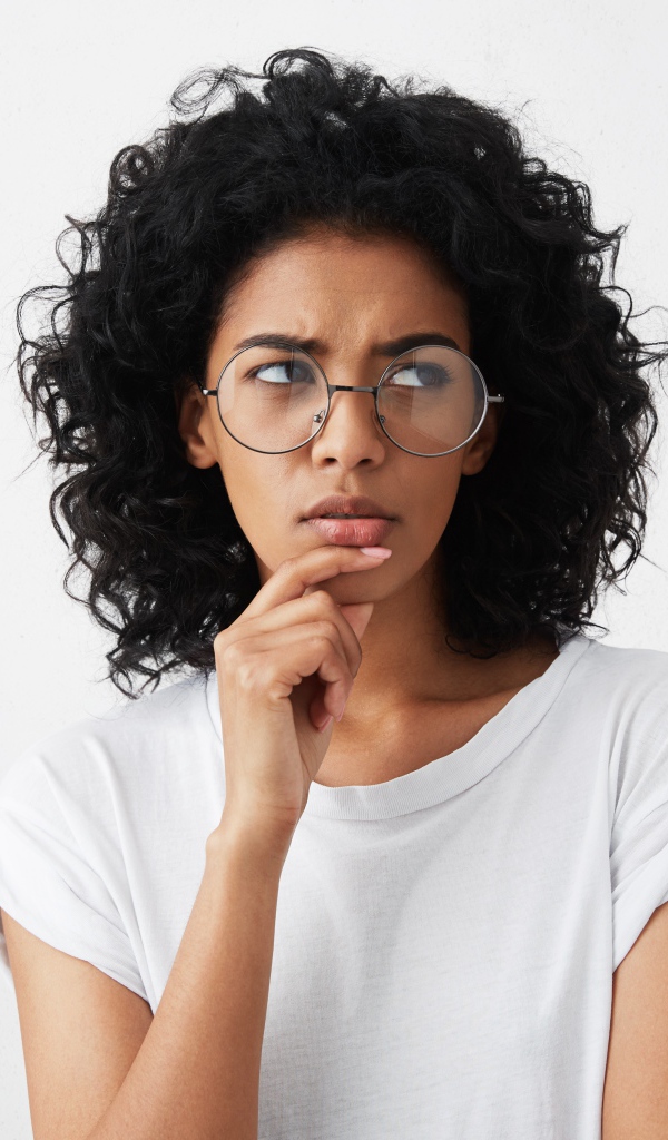 Темноволосая девушка в очках на сером фоне