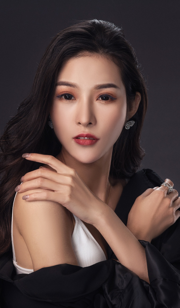 Нежная длинноволосая азиатка на сером фоне