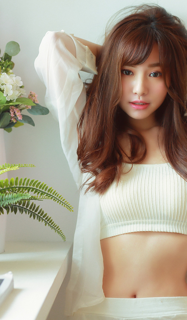 Нежная девушка азиатка стоит у окна