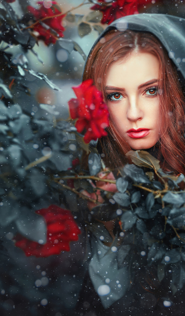 Девушка в черном плаще у  куста роз 