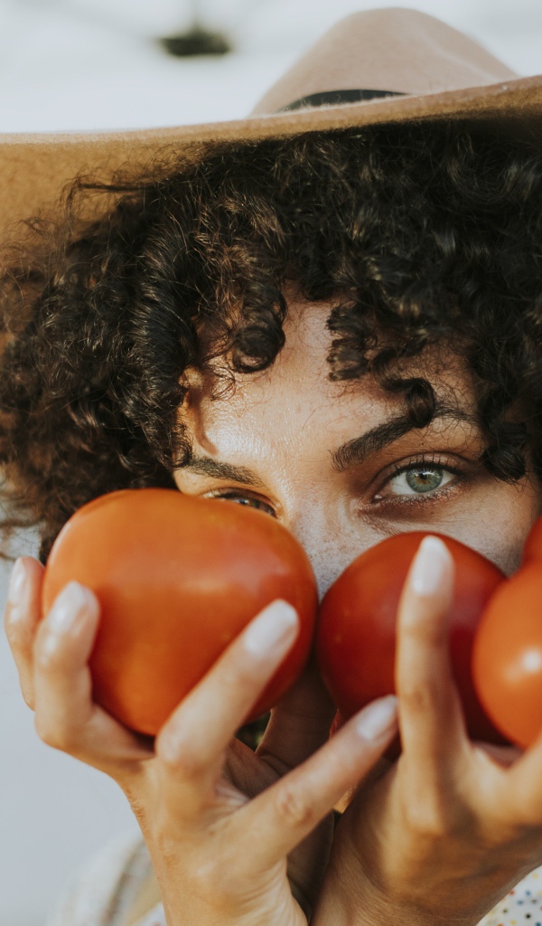 Девушка в шляпе с помидорами в руках 