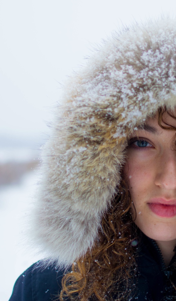 Девушка в заснеженном капюшоне на улице
