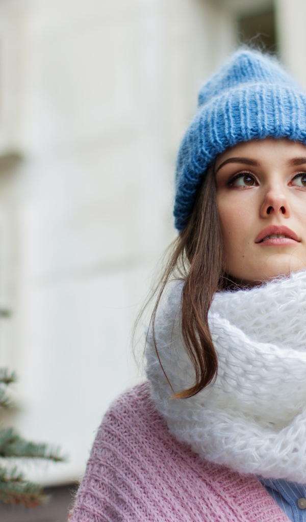 Girl in a warm blue hat with a white scarf