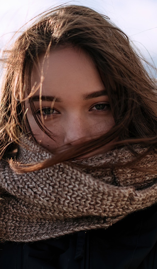 Девушка с теплым вязаным шарфом на лице