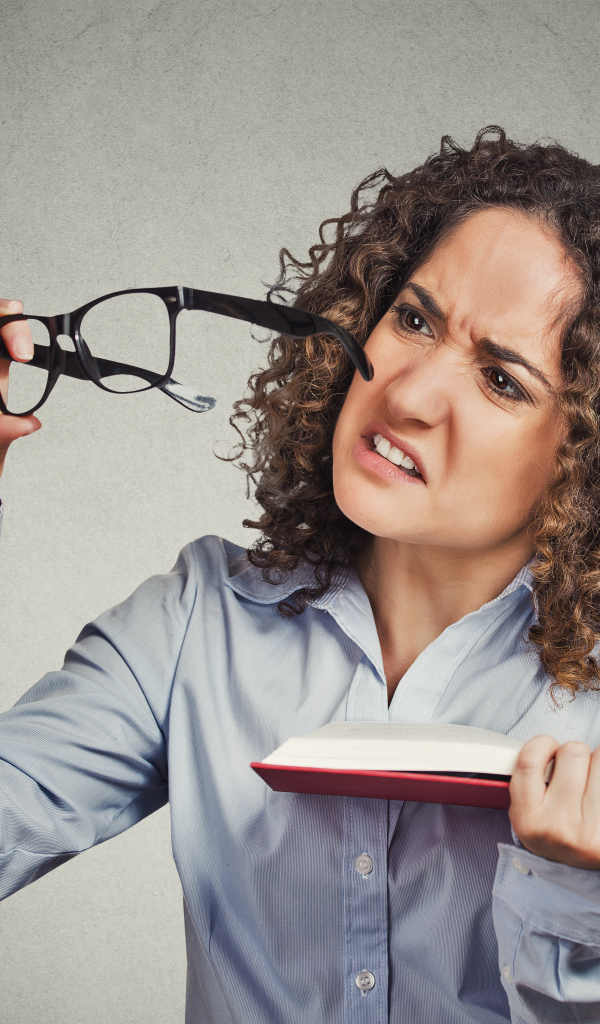 Девушка с книгой с очками в руке