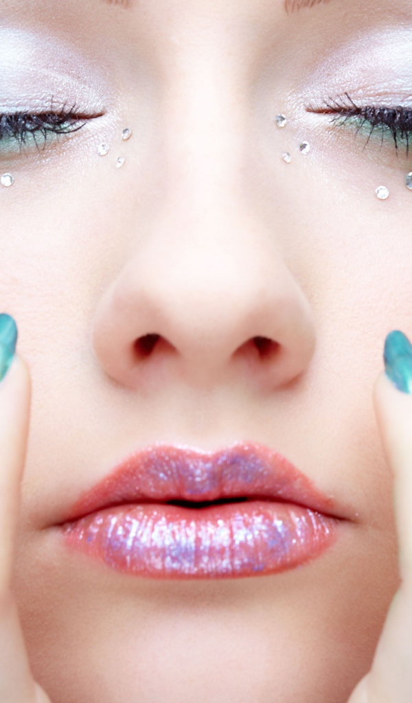 Девушка  с ярким макияжем и стразами на лице 