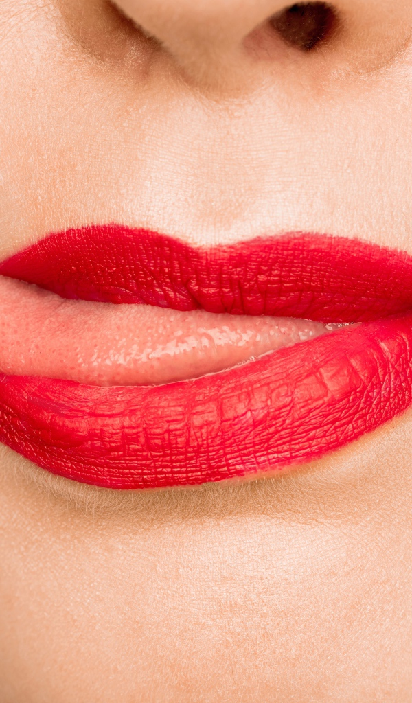 Девушка с  красными губами показывает язык