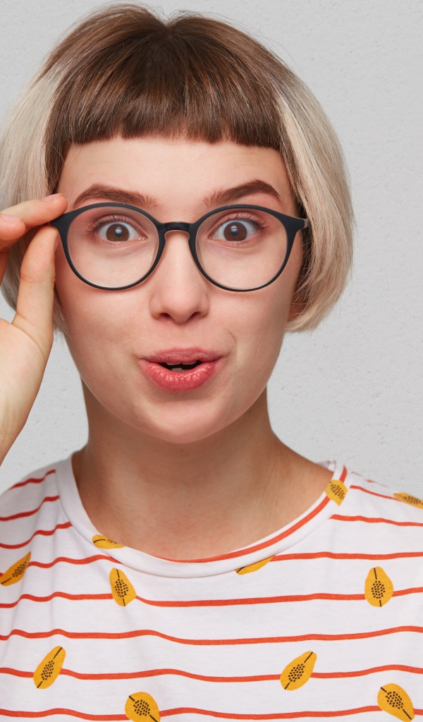 Девушка с короткой стрижкой поправляет очки 