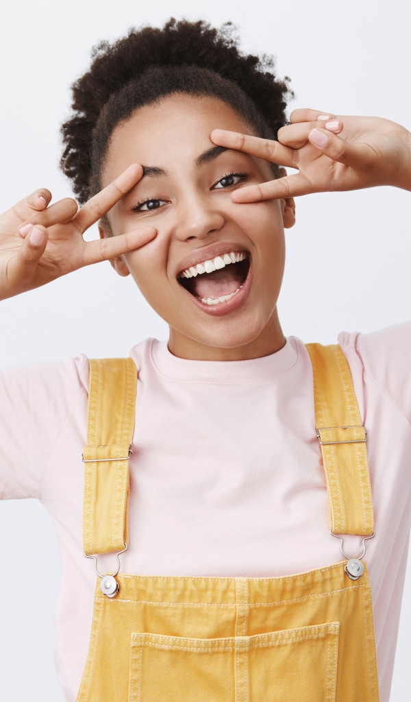 Счастливая девушка с руками у лица 