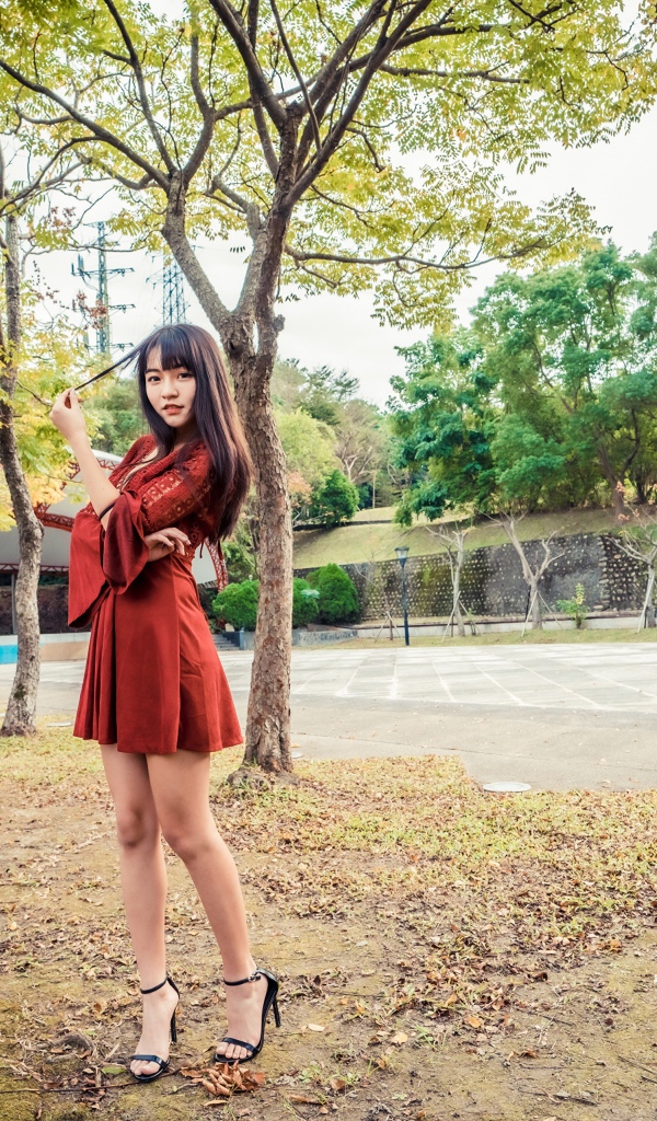 Длинноногая девушка азиатка в коротком красном платье 