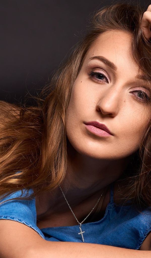 Длинноволосая шатенка лежит на полу в голубом платье 