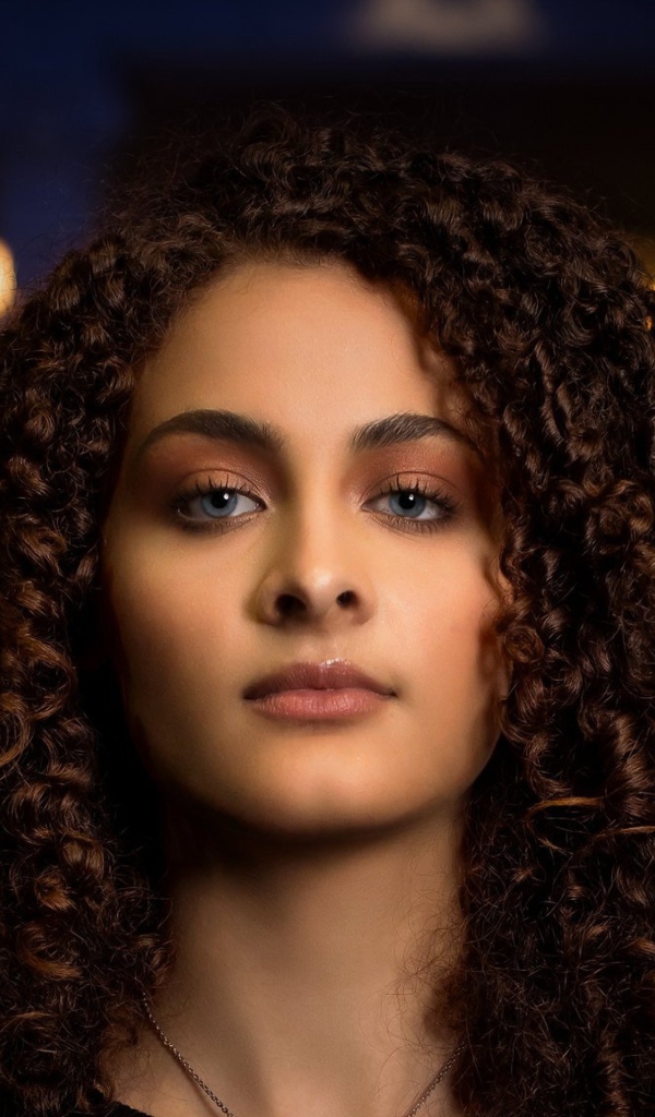 Длинные кудрявые волосы у красивой голубоглазой девушки