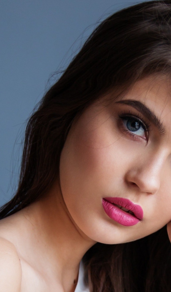 Милая девушка с розовыми губами на сером фоне