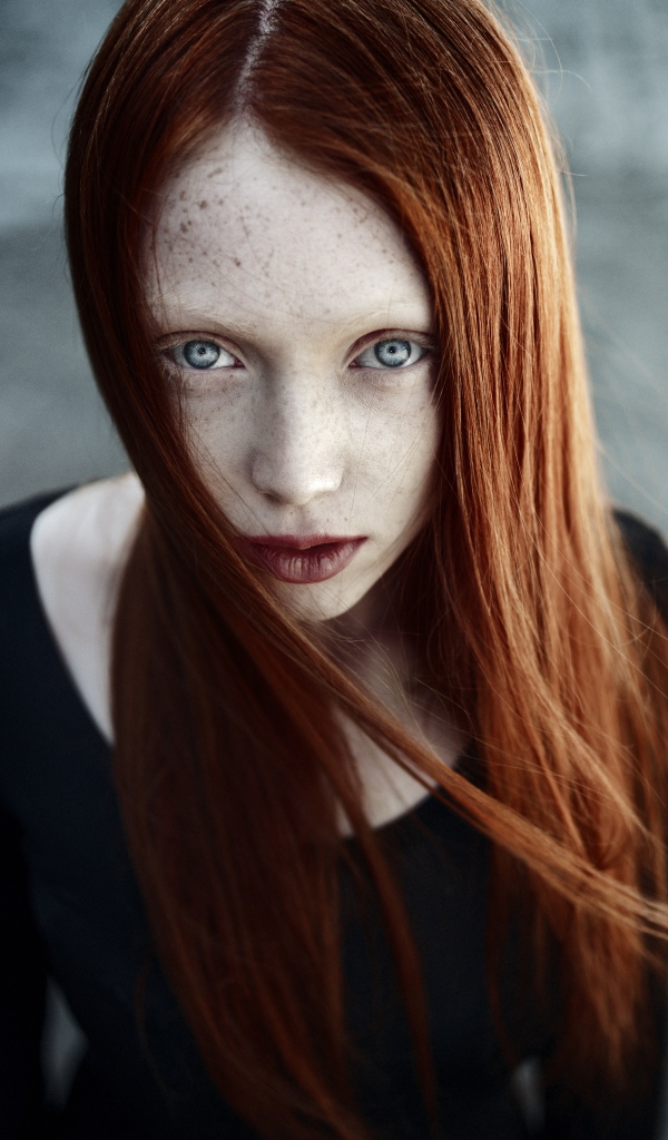 Рыжая длинноволосая девушка с веснушками на лице