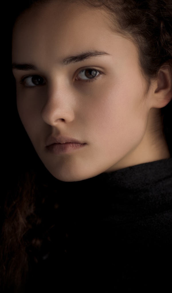 Грустная кареглазая девушка с длинными волосами