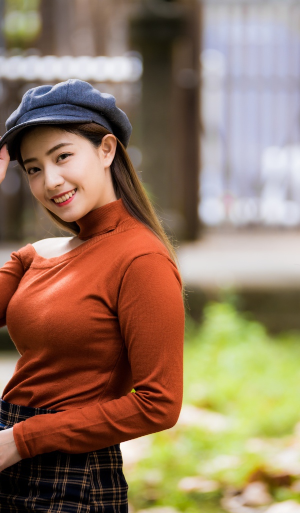 Улыбающаяся девушка азиатка в кепке 