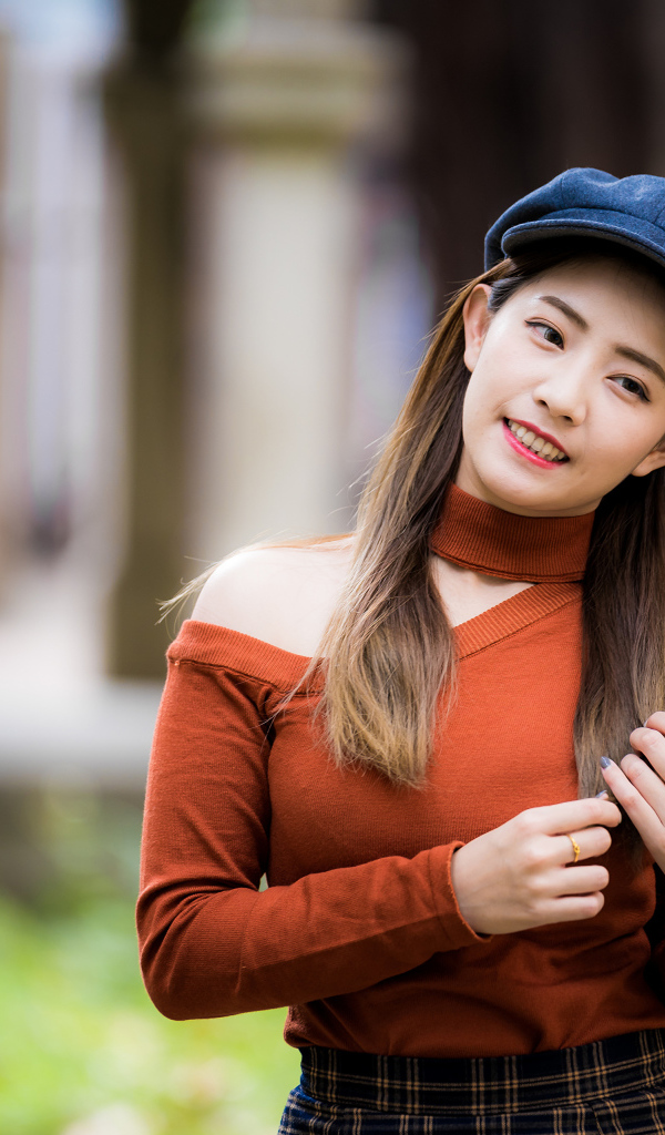 Улыбающаяся азиатка в черной кепке 