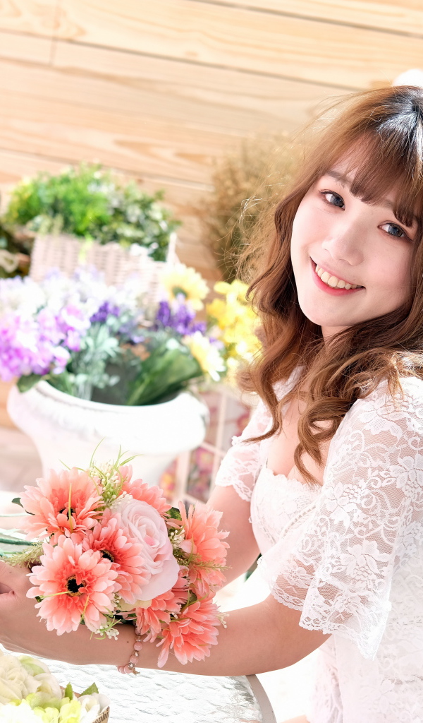 Улыбающаяся девушка азиатка в белом кружевном платье 