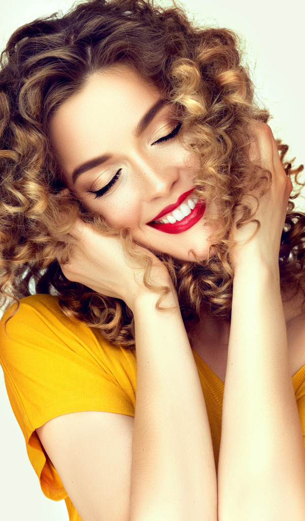 Улыбающаяся девушка с закрытыми глазами на белом фоне