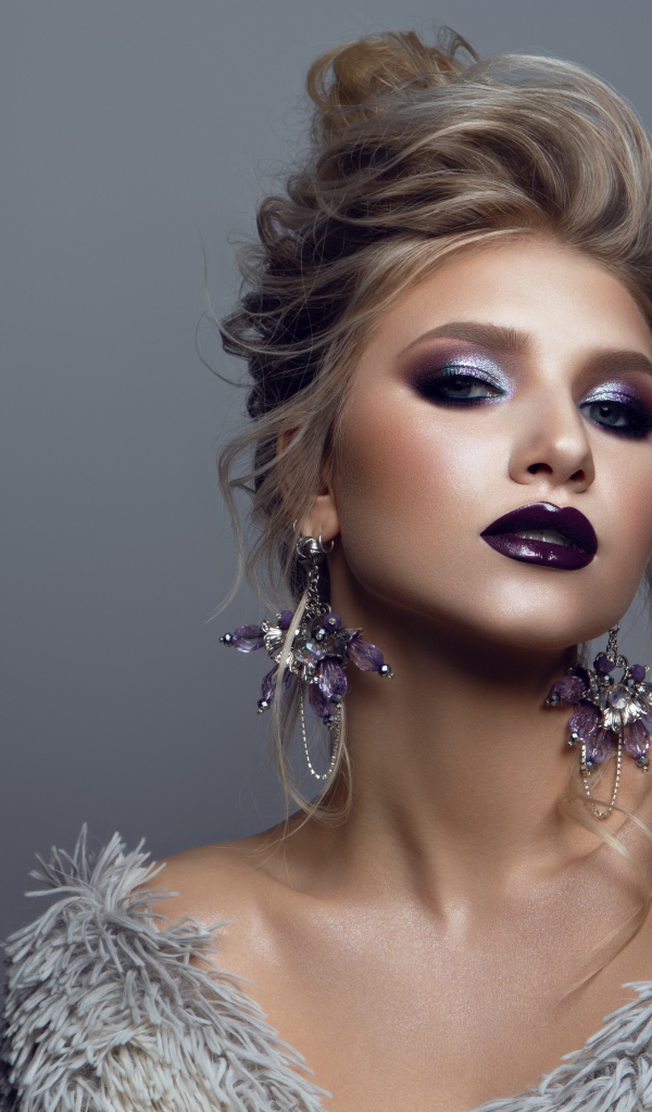 Эффектная девушка с ярким макияжем на сером фоне