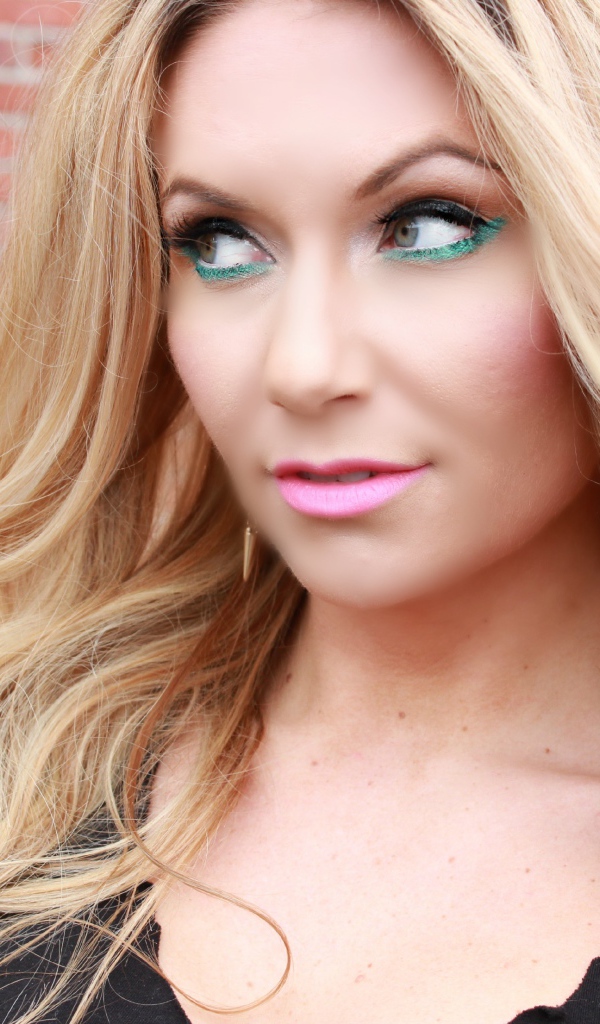 Эффектная длинноволосая блондинка у стены 