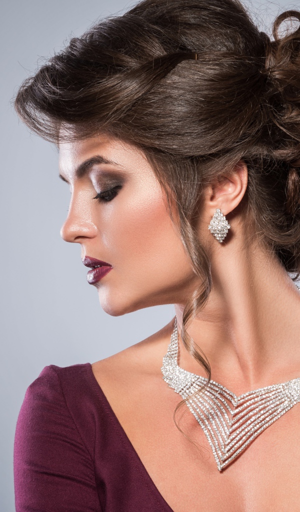 Стильная женщина с вечерней прической, макияжем и дорогими украшениями