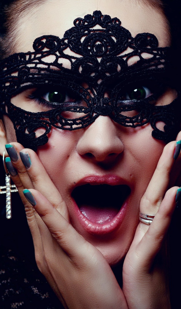 Удивленная девушка в черной маске на лице