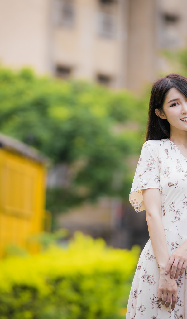 Нежная улыбающаяся азиатка в красивом платье 