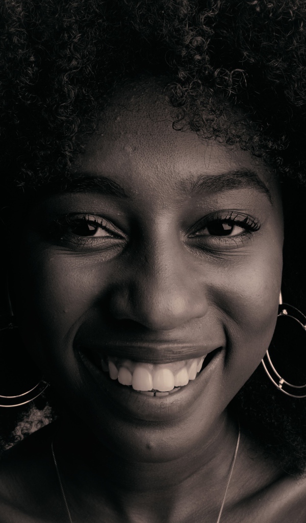 Лицо улыбающейся темнокожей девушки  