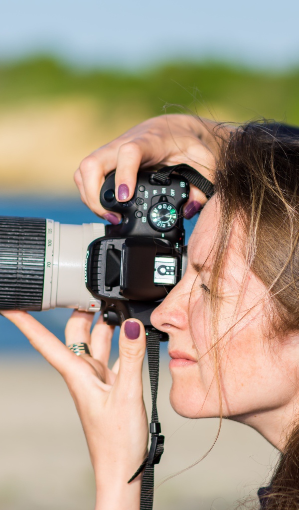 Девушкой делает фото на фотоаппарат 