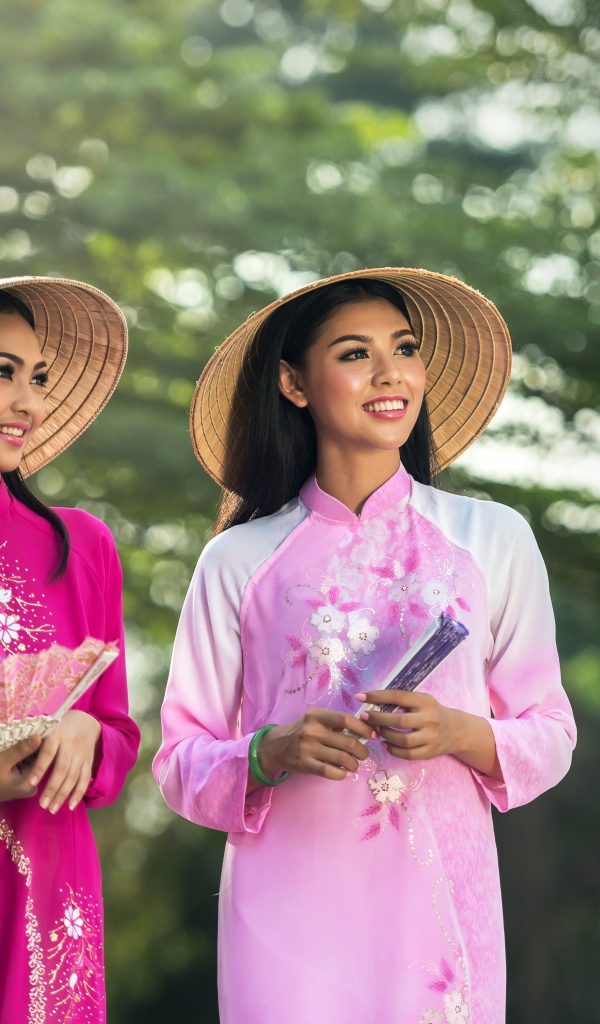 Две девушки азиатки в платьях с веером в руках