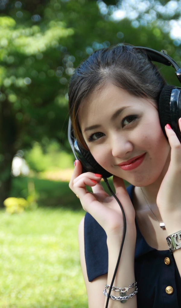 Молодая девушка азиатка в больших наушниках 