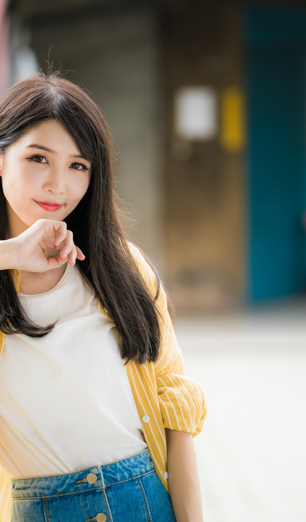 Молодая азиатка в белой майке и полосатой рубашке 