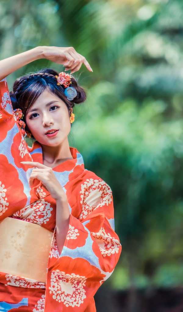 Молодая азиатка в кимоно в парке 