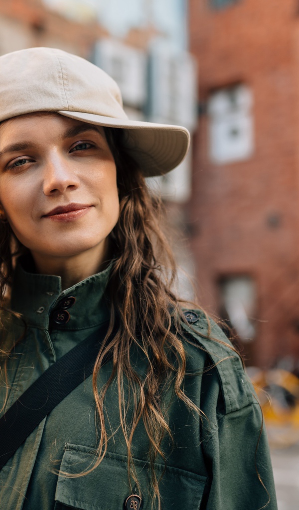 Молодая модная девушка в кепке в городе