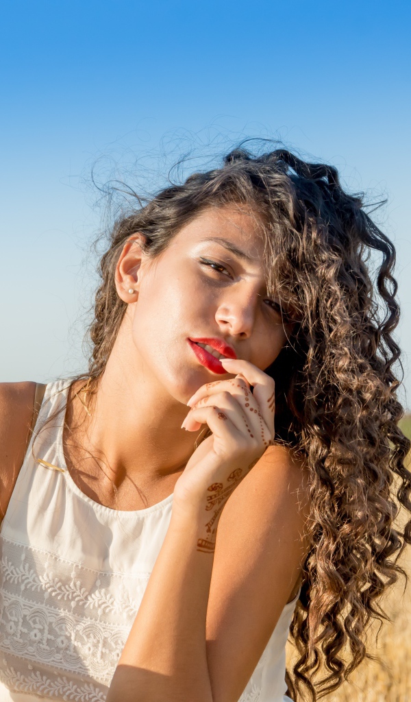 Молодая девушка в белом платье на пшеничном поле