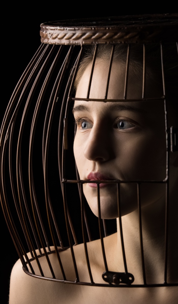 Молодая девушка с клеткой на голове 