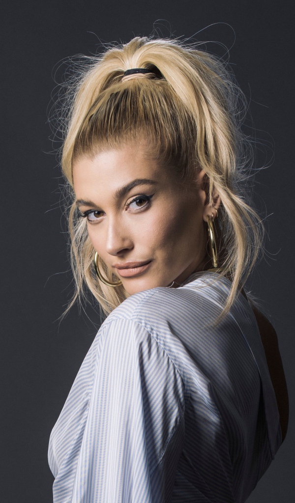 Красивая блондинка, американская модель Хейли Болдуин на сером фоне