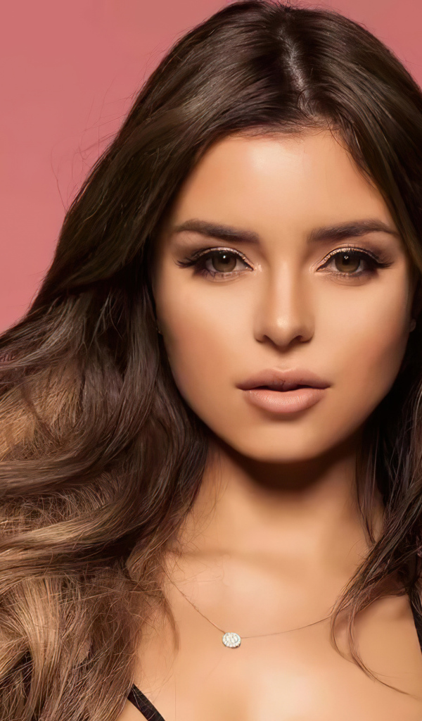 Красивая длинноволосая модель Деми Роуз на розовом фоне