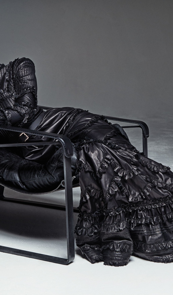 Beautiful model Hayley Baldwin in a long dress lies in an armchair