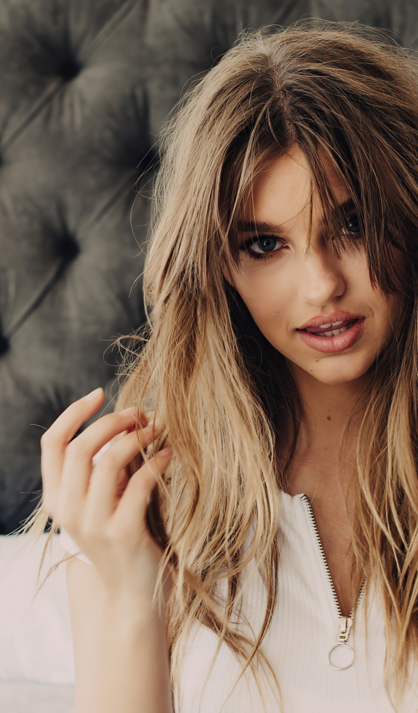 Красивая модель Оливия Брауэр сидит на диване