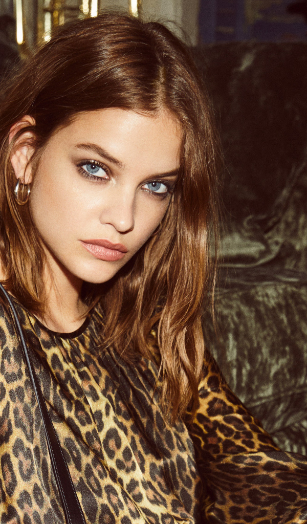 Model Barbara Palvin in a leopard dress by the sofa