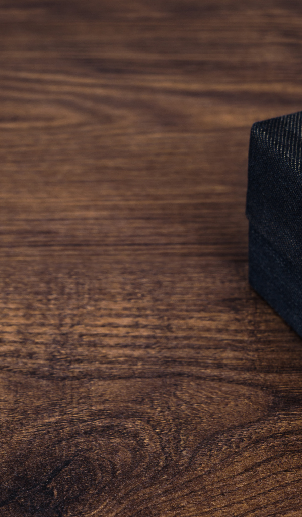 Подарок с синим бантом на деревянном столе 