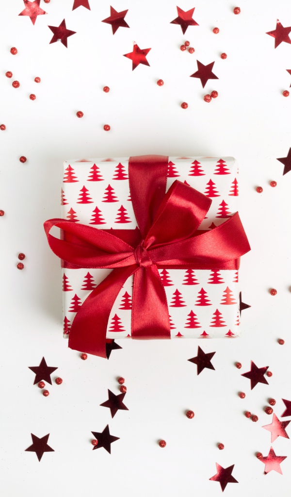 Gift with a red bow on a white background with stars