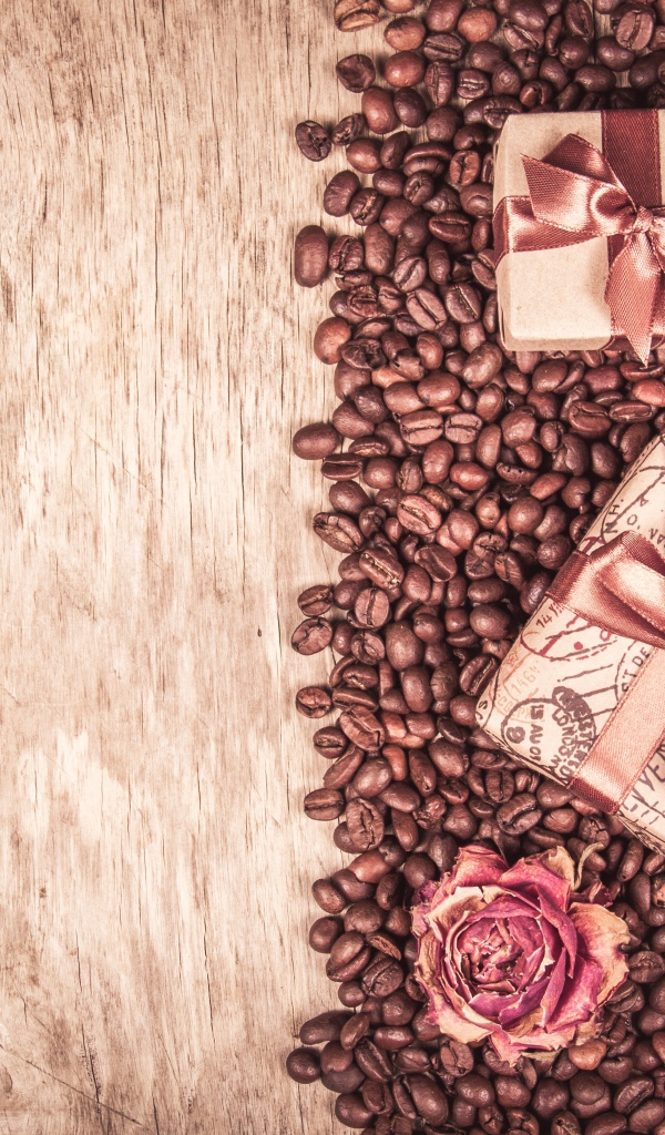 Подарки и розы лежат на кофейных зернах