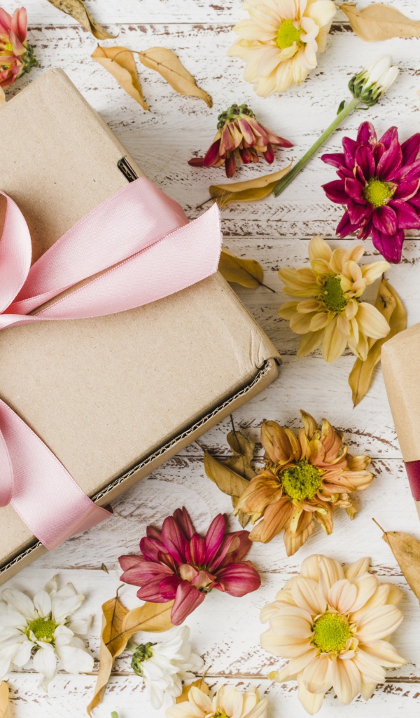 Две коробки с подарками на столе с цветами хризантемы