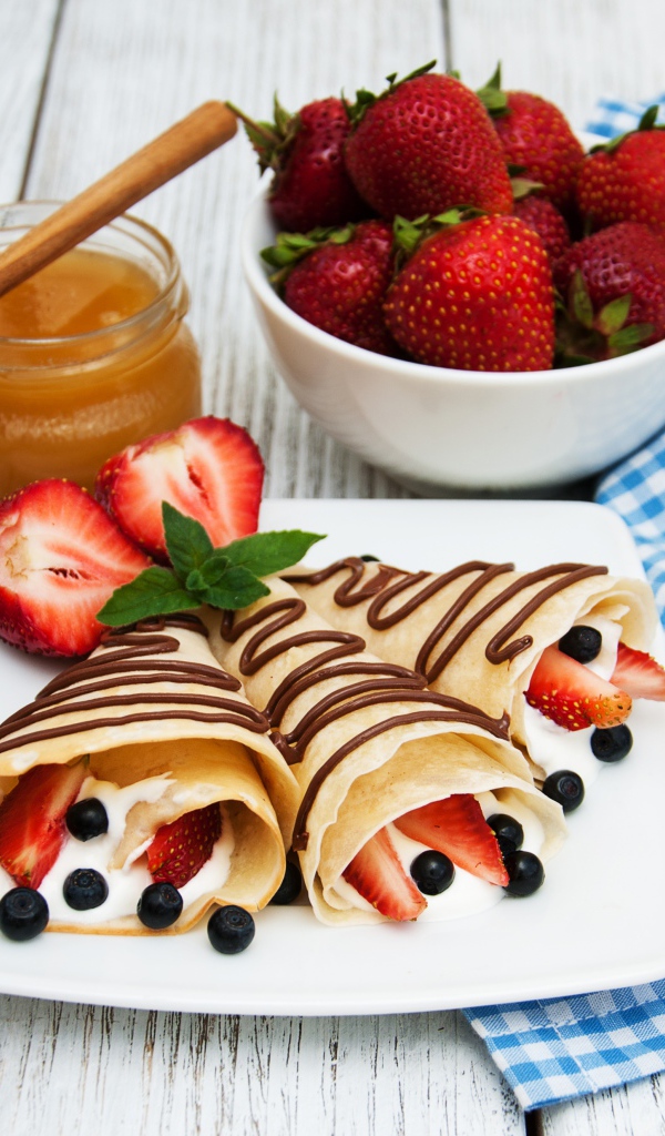 Pancakes with sour cream, blueberries and strawberries on Maslenitsa